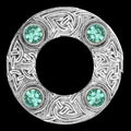 Decorative ring with Celtic knot design and green gemstones on a white background